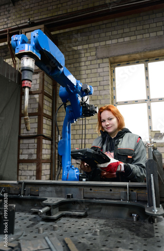 Female worker and robot in manufacturing shop