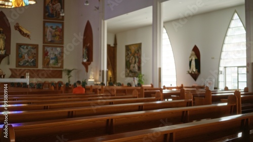 Church interior with defocused wooden pews, shallow bokeh and soft light from arched windows, altar and religious icons out of focus; background backplate copyspace calm.