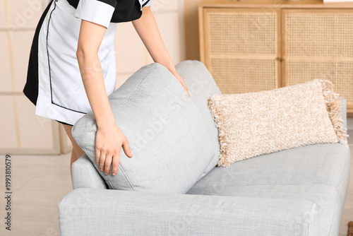 Female maid putting cushion...
