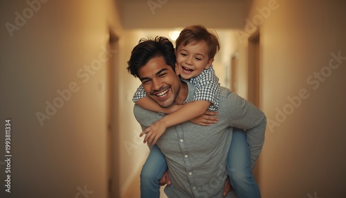 A Latino father giving his young son a piggyback ride down a hallway with joyful smiles