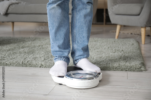 Young man measuring weight ...