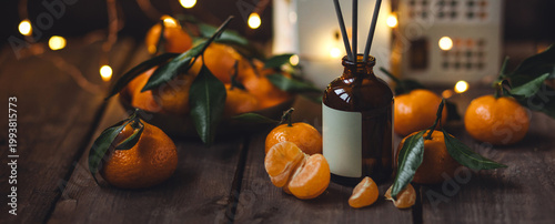 Xmas spirit, creating holiday atmosphere, festive christmas mood at home. Scented liquid reed diffuser with sticks with flavor of fresh citrus. Cozy atmosphere, house air freshener. Dark background