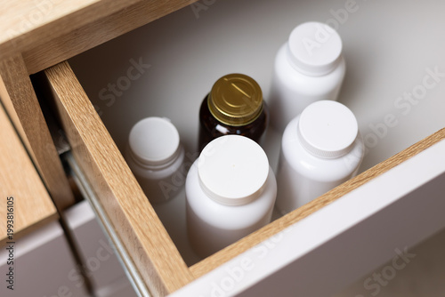 Bottles of vitamins and mineral supplements are stored in a drawer.