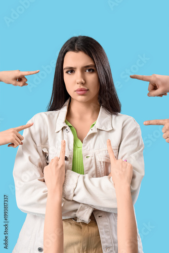 Photos People pointing at sad young woman on blue background