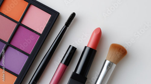 Assortment of colorful makeup products including eyeshadow palette, lipstick, and brushes on white background