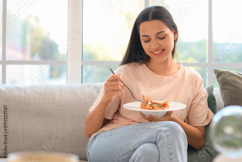 Young woman eating tasty pa...