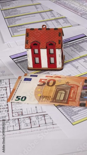 Close-up of hands counting euro cash over construction cost documents with a house model and architectural blueprints, symbolizing budgeting, real estate planning, and building expense calculation. 