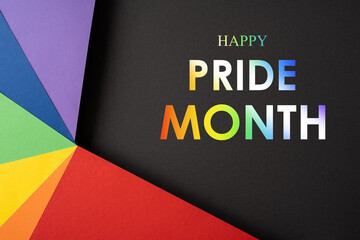 Colorful rainbow paper fan on black background representing Pride Month and diversity celebration