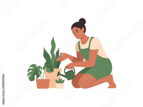 A woman in green overalls is kneeling and watering plants with a watering can in a serene and peaceful environment.