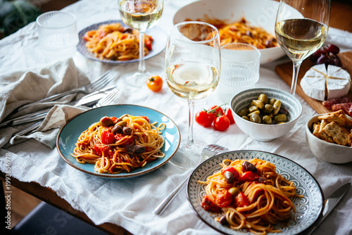Friends having a pasta dinner with wine at home.