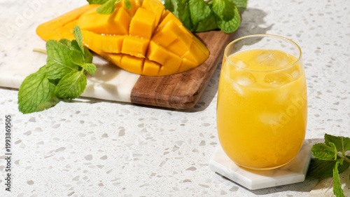 Cuadro en lienzo Summer mango drink mocktail with ice and mint on terrazzo countertop, bright ref