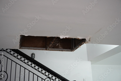 Fotografía Damaged ceiling with a large hole revealing the interior structure