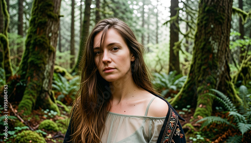 Portrait of a young woman in a lush, moss-covered forest