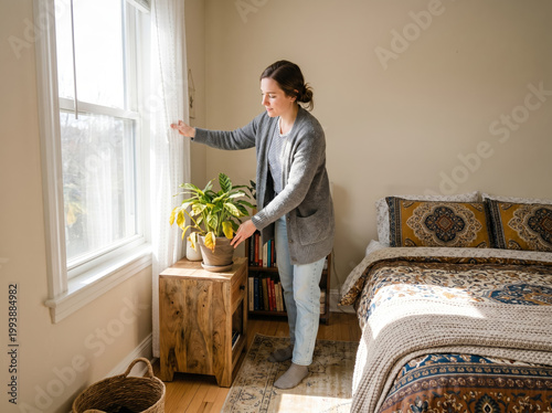 Female resident tending to indoor foliage beside sunlit window, home care routine, domestic tranquility, natural light ambiance, houseplant maintenance.