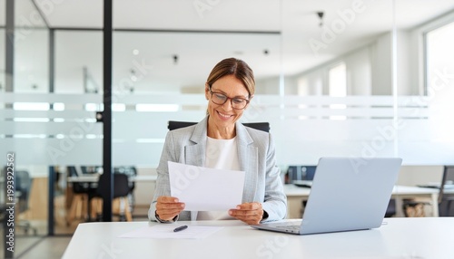 Woman Reading Paper At Desk.