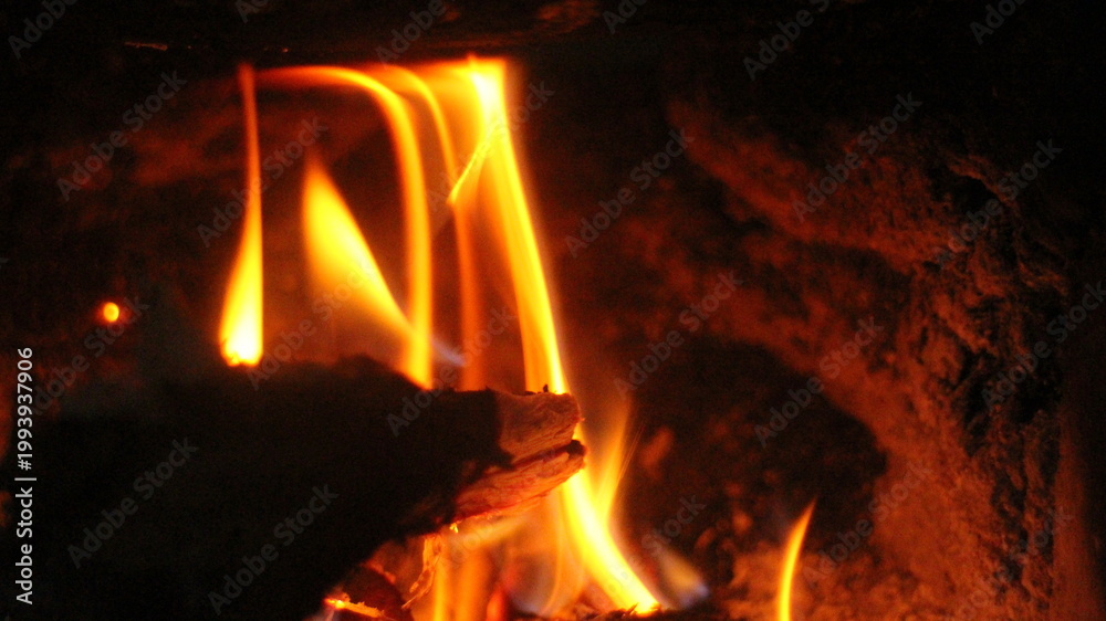 Αυτοκόλλητο Close up of burning wood logs blazing in flames inside black wrought iron wood burning fire