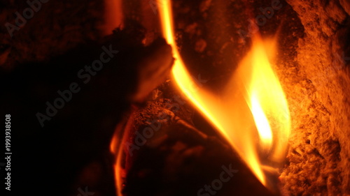 Fotografie Close up of burning wood logs blazing in flames inside black wrought iron wood burning fire