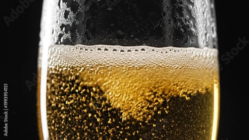 Close-up of golden beer being poured into a glass with bubbles rising.