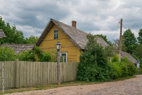 A traditional Russian wooden village house on the main street of Izborsk - Pechorskaya - on a sunny summer day, Izborsk, Pskov region, Russia