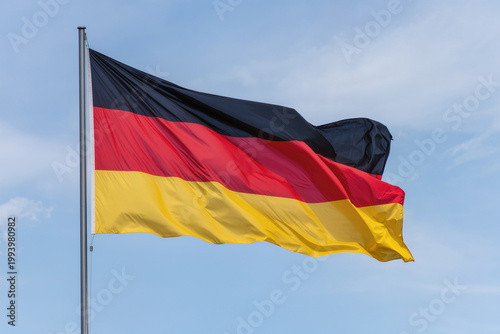 German flag fluttering in the blue sky