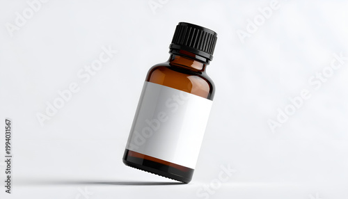 Amber glass bottle with blank label for essential oils or medicine studio shot on white backdrop tilted angle emphasizing clean minimalist design