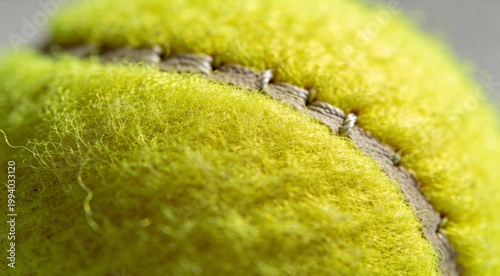 Extreme macro of yellow tennis ball felt and stitching with detailed fuzzy texture