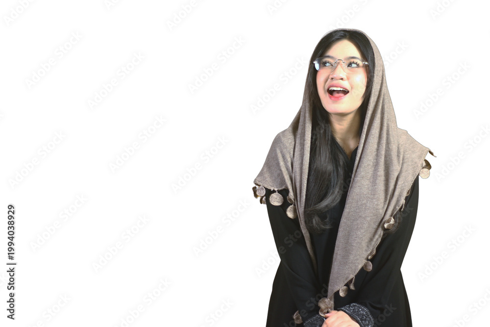 Naklejka premium Young woman wears hijab and glasses. She smiles warmly with joyful expression. Her eyes sparkle with happiness and surprise. Bright white background emphasizes her cheerful face