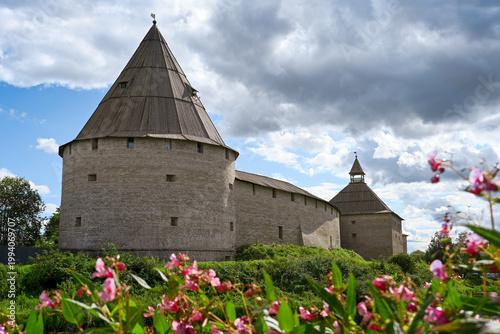 Vászonkép Towers and walls of the Staraya Ladoga Fortress framed by flowers, Leningrad reg