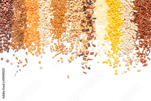 Top view of various grains, pulses, and legumes arranged in vertical gradients on white background.