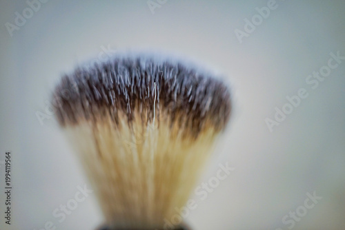 Traditional shaving brush standing upright with soft bristles in clean setting