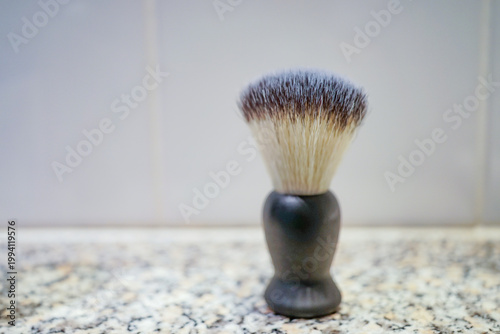 Traditional shaving brush standing upright with soft bristles in clean setting