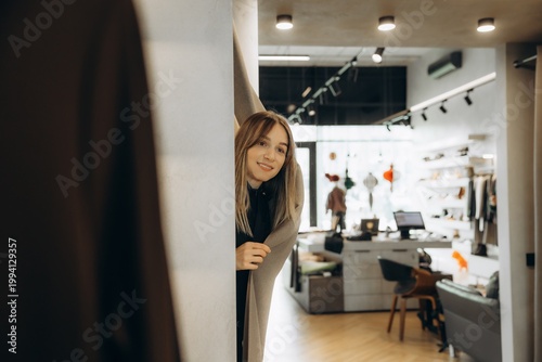Foto Young woman peeking from changing room curtain