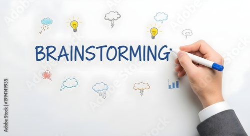 Close up of a businessmans hand in a suit writing the word brainstorming on a white board with colorful icons representing ideas