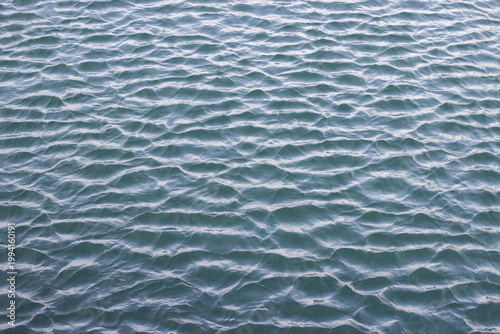 Cuadro en lienzo Surface of calm water with gentle ripples reflecting light, creating a serene an