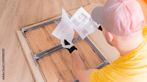 Фотография The furniture assembler opened the instructions for assembling the table