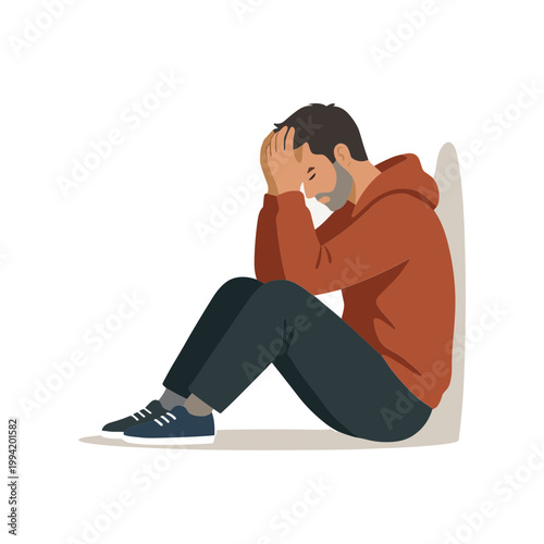A man sits on the floor with his head in his hands feeling emotions
