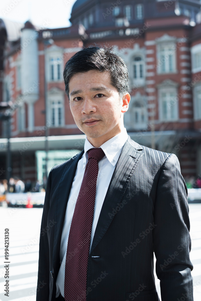 Fototapeta premium 駅前の40代男性ビジネスマンのポートレート
