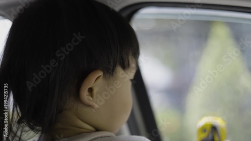 Little Child Playing With Toy Car Inside Vehicle, A video a child playing with a toy car inside a vehicle, innocent road trip fun, perfect for family lifestyle documentary and children product.