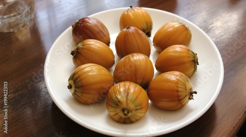 Close up of Freshly Harvested Oval Shaped Fruits on a White Plate
