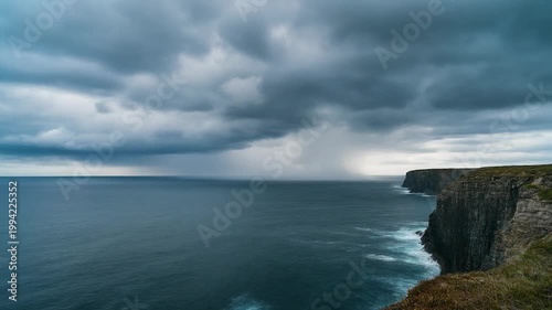 Dramatic stormy weather approaches rugged coastal cliffs and ocean waves