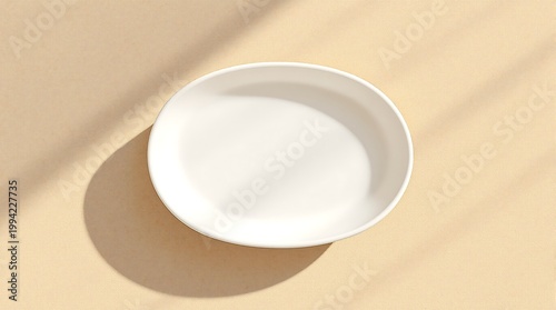 Clean White Plate on a Beige Surface with Natural Light Shadows