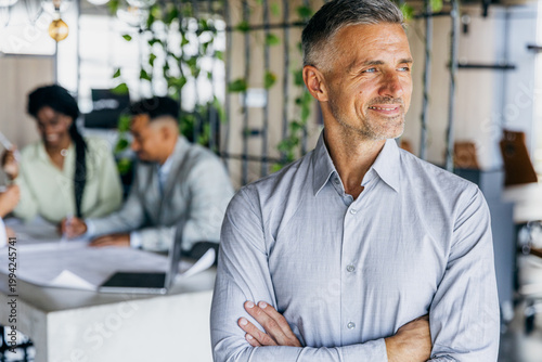 Selfassured Caucasian manager watching team collaborate closely