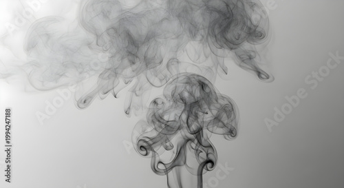 Smoke swirls elegantly forming shapes on a grey background