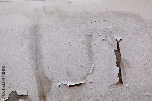 Peeling paint on white wall texture caused by water damage