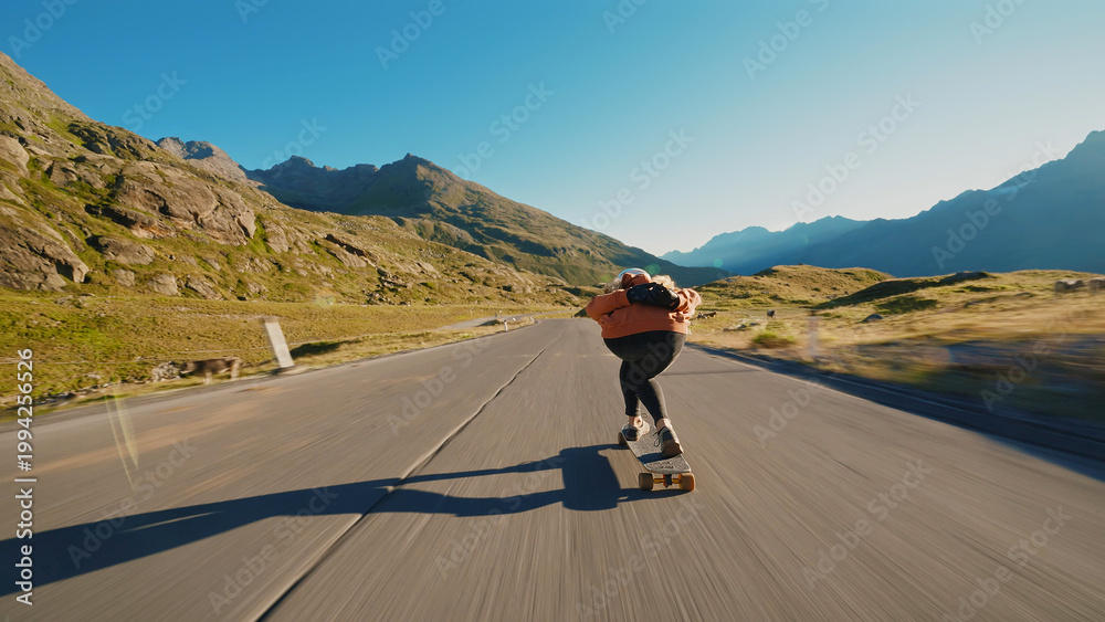 Fototapeta premium woman skateboarding and making tricks between the curves on a mountain pass.