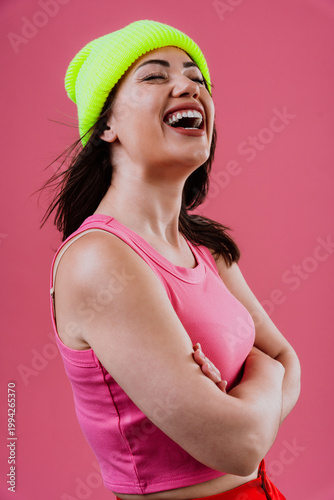 Happy young woman laughing wearing neon beanie