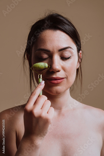 Woman enjoying facial skincare with jade roller