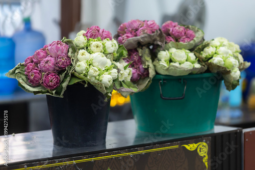 folded pink lotus flower bouquet wrapped in large green leaf resting peacefully for Buddhist to pay respect worship to Buddha at Wat Yai is a Buddhist temple is Public places in Phitsanulok,Thailand.