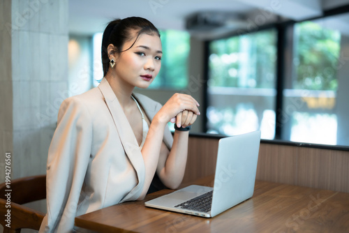 Portrait of asian freelance people businesswoman casual working with laptop computer in cafe interior in coffee shop background,business expressed confidence embolden and successful concept