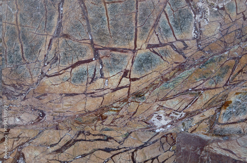 Abstract multi-colored background in subdued light and texture reminiscent of natural stone.